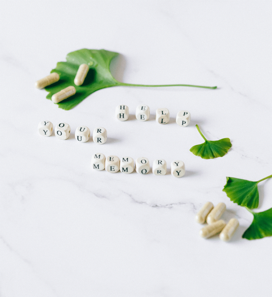 des gélules sont posées sur des feuilles de ginkgo biloba à côté desquelles figurent le texte aide votre mémoire