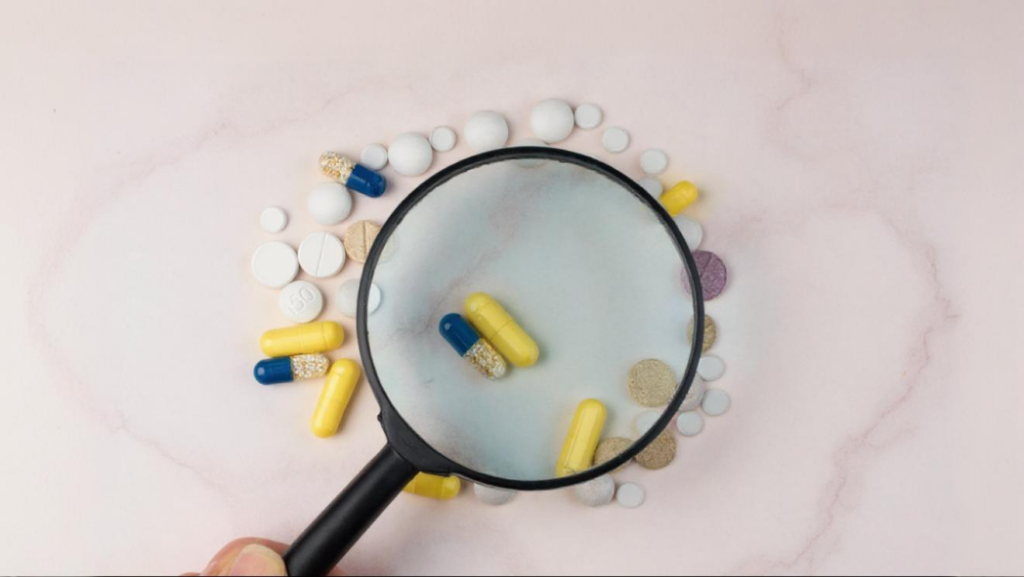 Une loupe zoom sur des gélules de compléments alimentaires pour les analyser